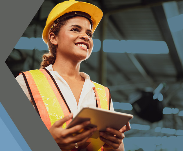 woman in hard hat and safety vest holding a clipboard
