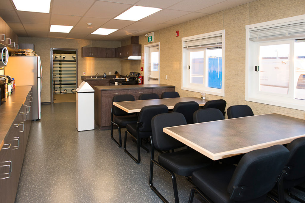 interior of relocatable structure showing kitchen area and tables