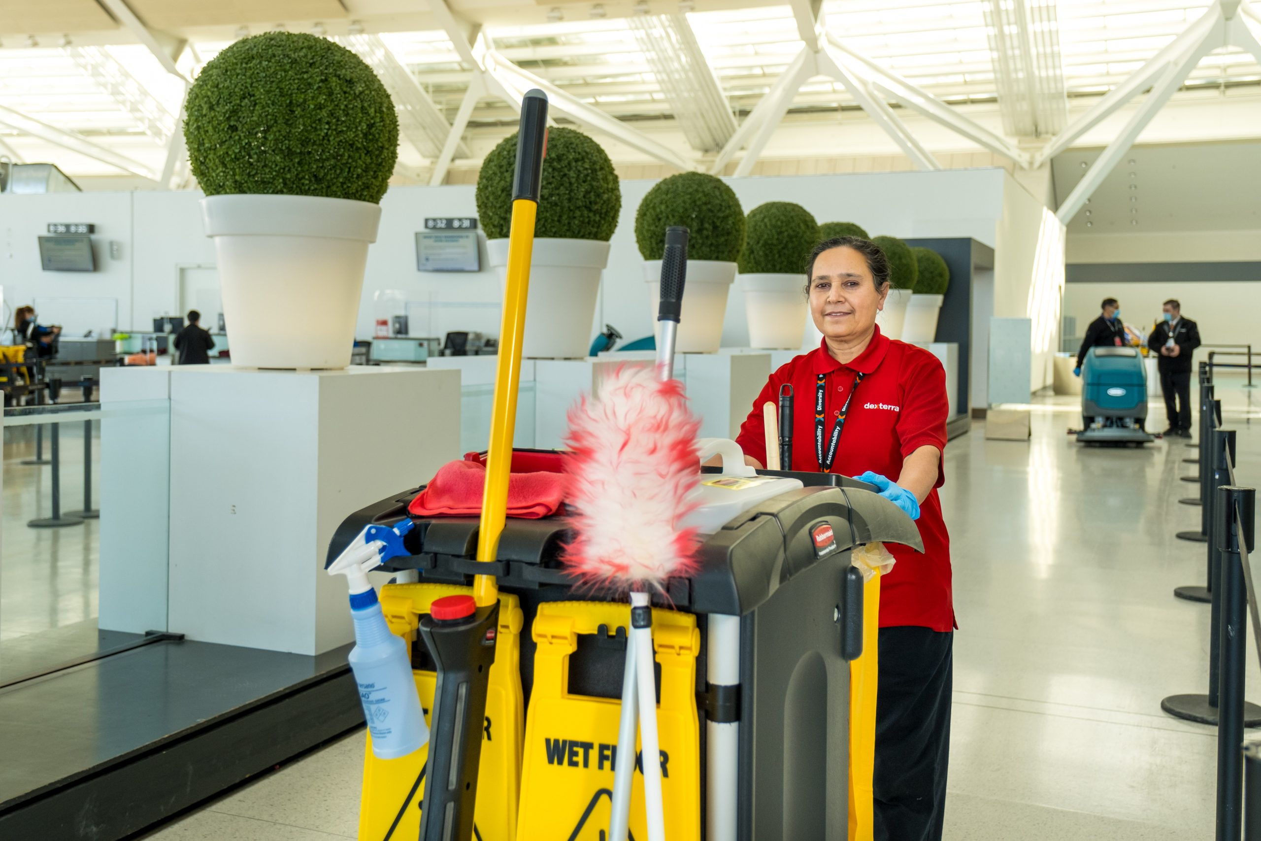 A member of the cleaning staff with a cart of supplies