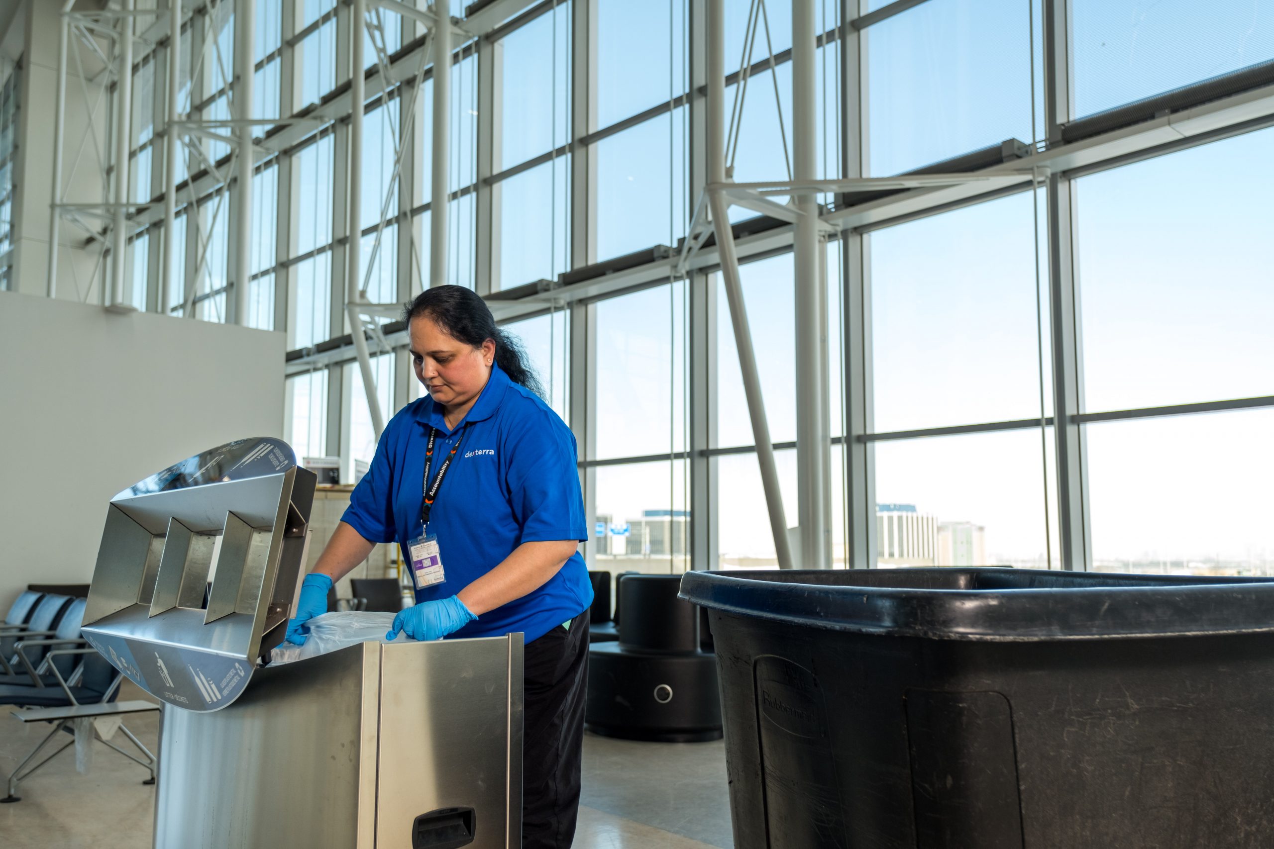 A woman emptying recycling bins
